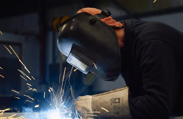 A welder at MEBA welds together components of a MEBA bandsaw